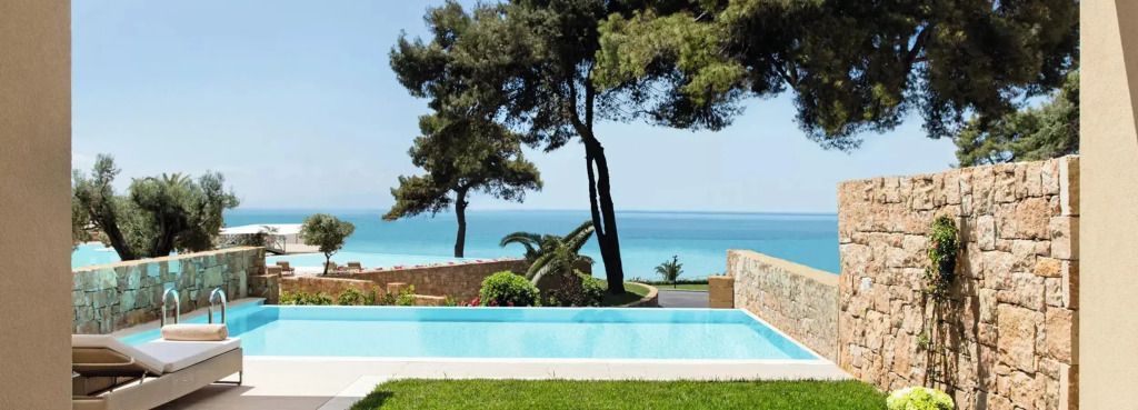 Infinity-Pool im Garten mit Blick auf das Meer und Pinienbäume