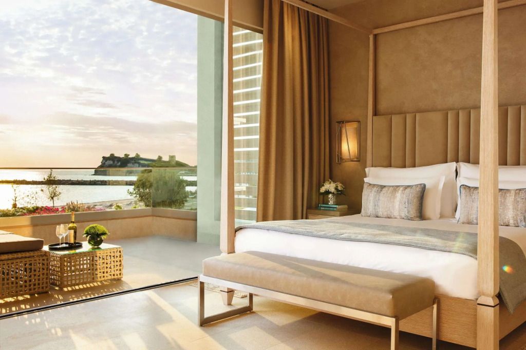Elegantes Schlafzimmer mit Balkon und Meerblick bei Sonnenuntergang