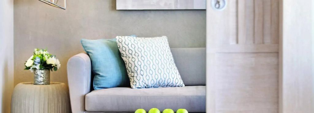 Designer-Sofa mit dekorativen Kissen und grünen Akzenten