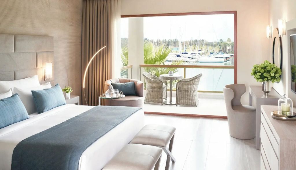 Helles Marina Deluxe Zimmer mit Sofa und Hafenblick vom Balkon