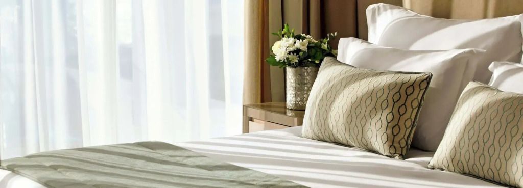 Detailansicht eines stilvollen Betts mit Blumenarrangement