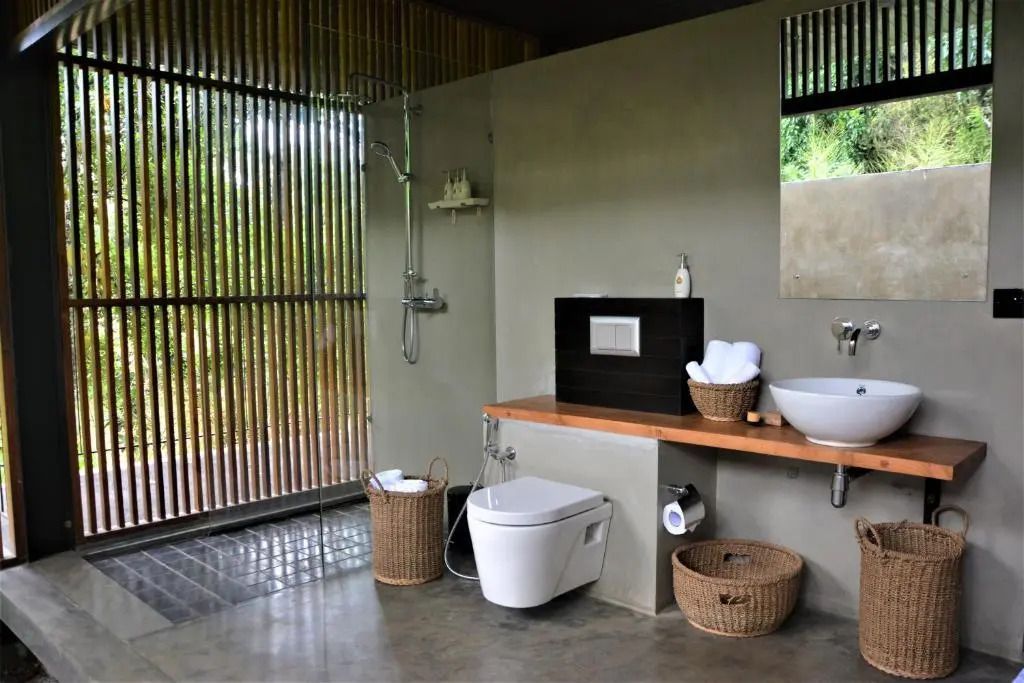 Modernes Badezimmer mit Dusche, Toilette und stilvoller Waschgelegenheit mit Gartenblick