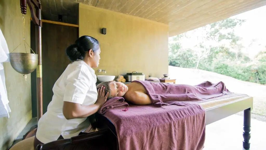 Frau erhält entspannende Massage in einem Raum mit natürlichem Ausblick