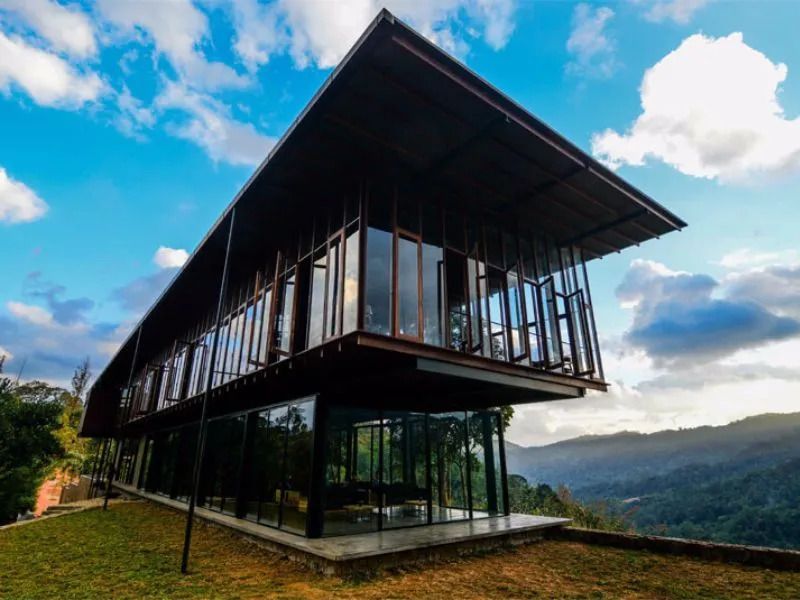 Modernes Gebäude mit großen Glasfenstern und Bergblick unter blauem Himmel
