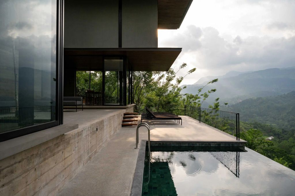 Infinity-Pool vor Bergkulisse mit Ruhebereich aus Holz
