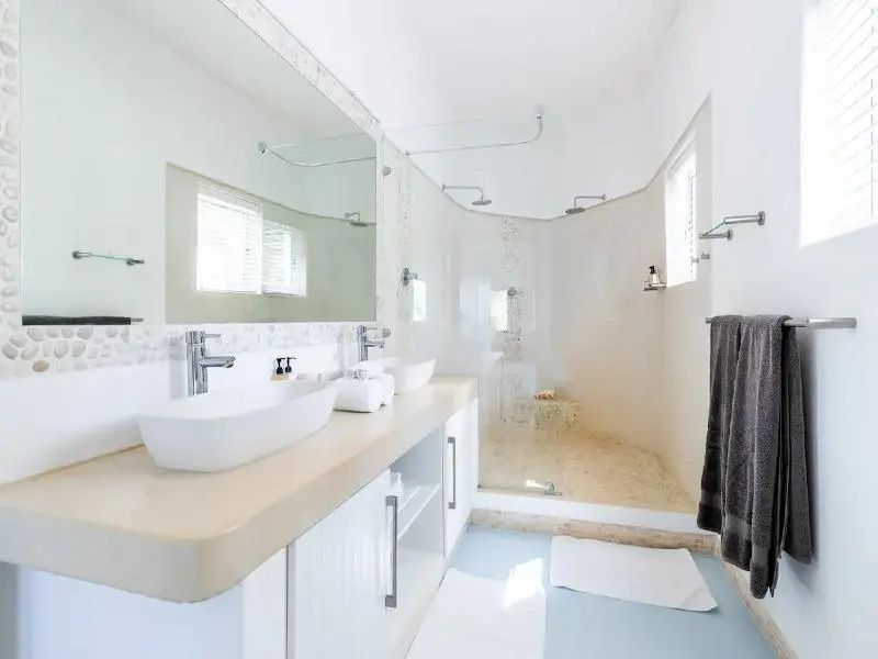Modernes Badezimmer mit großer Dusche und Doppelwaschbecken in heller Farbgebung
