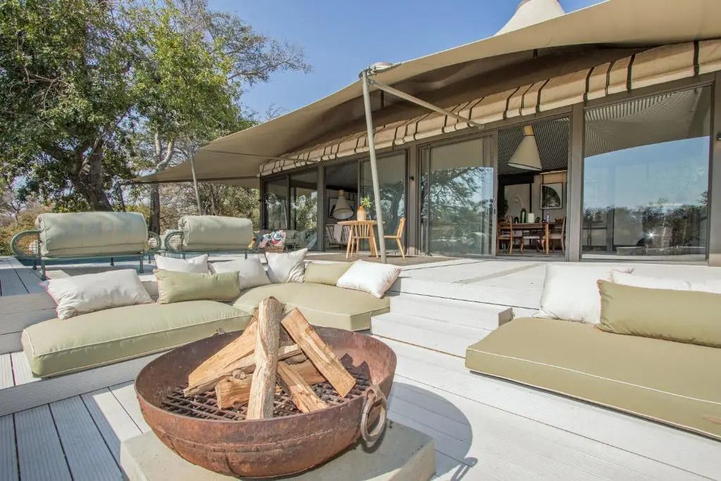 Außenbereich der Villa im Saseka Tented Camp mit Lounge-Sitzbereich und Feuerstelle.