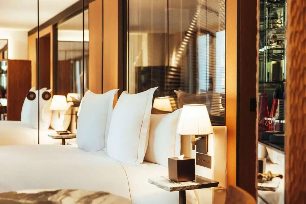 Elegantes Bett mit weichen weißen Kissen und stilvollen Nachttischlampen