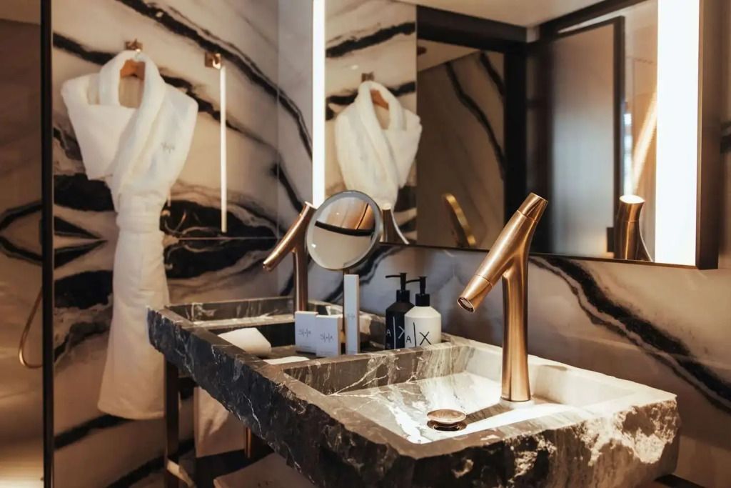 Modernes Badezimmer mit Designer-Waschbecken und goldenen Armaturen