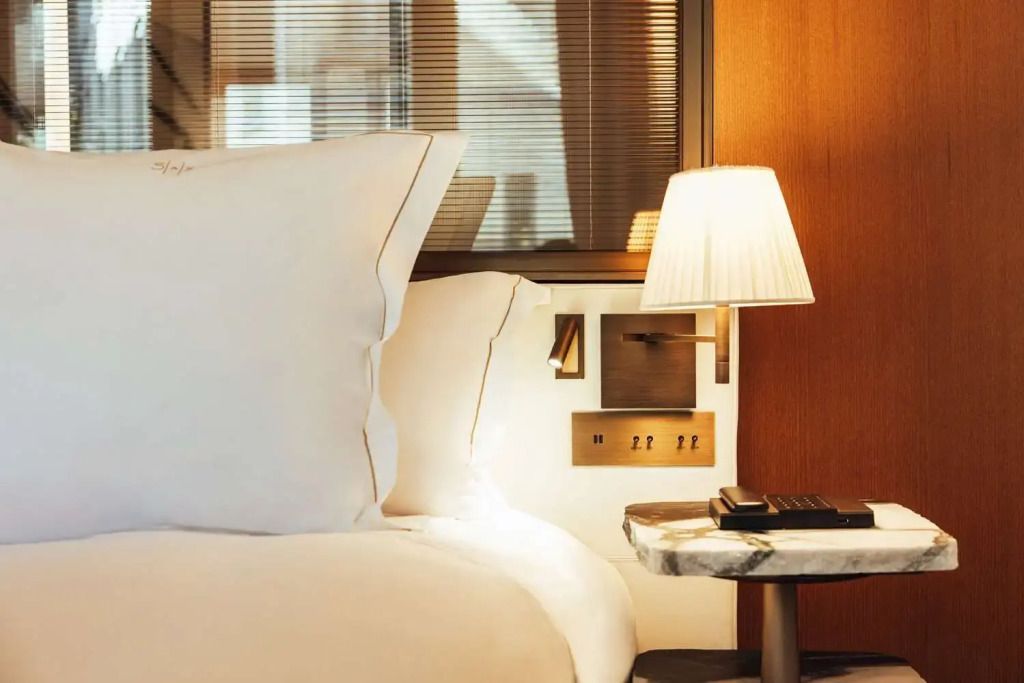Gemütliche Beleuchtung und elegante Bettwäsche im Deluxe Zimmer