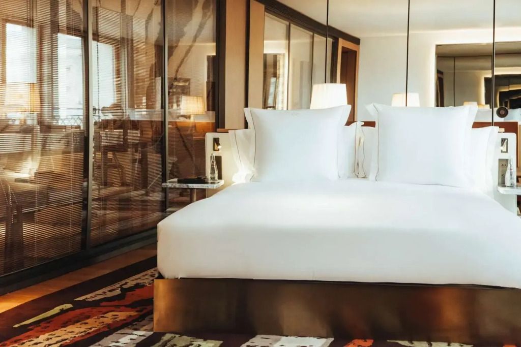 Elegantes Hotelzimmer mit großem Doppelbett und Glaswand im Prestige Doppel Familie Zimmer.