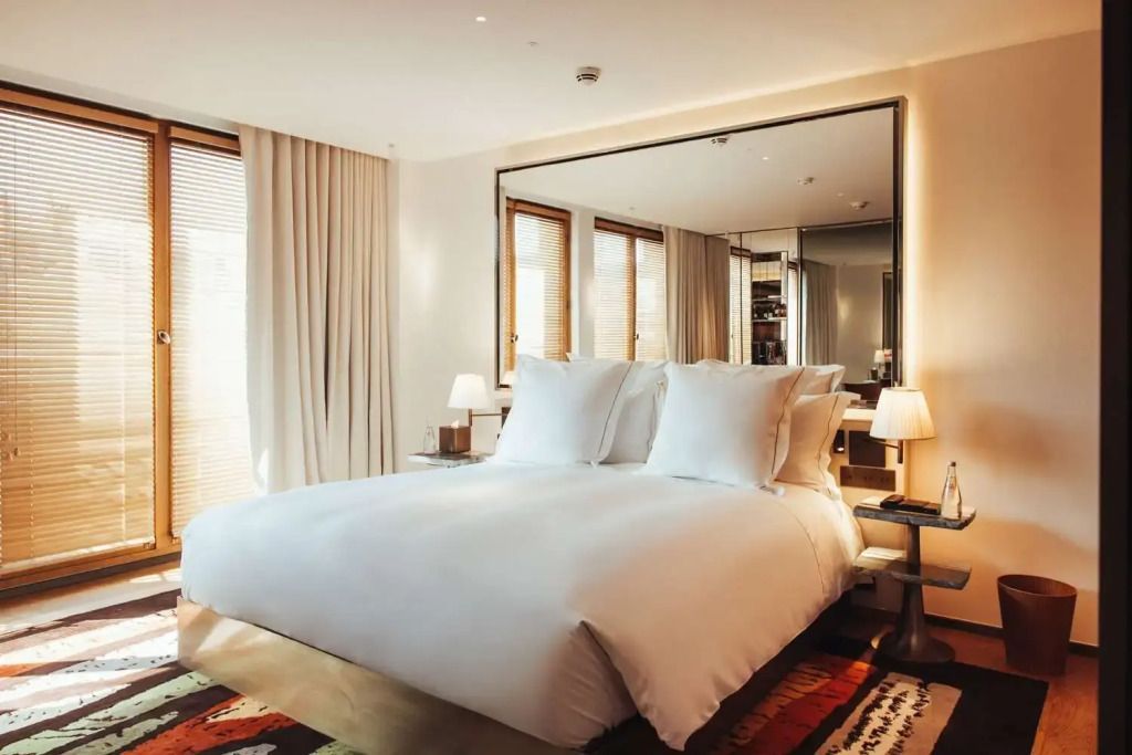 Komfortables Doppelbett im luxuriösen Hotelzimmer mit großem Spiegel an der Wand.