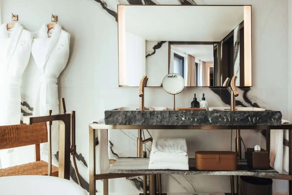 Luxuriöses Badezimmer mit edlen Materialien und Spiegelwand