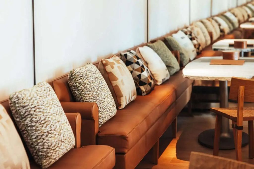 Elegante Sitzreihe mit dekorativen Kissen in einer Suite