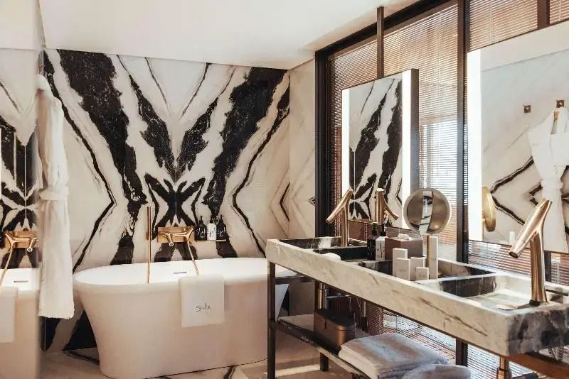 Modernes Badezimmer mit Marmorelementen und luxuriöser Badewanne.