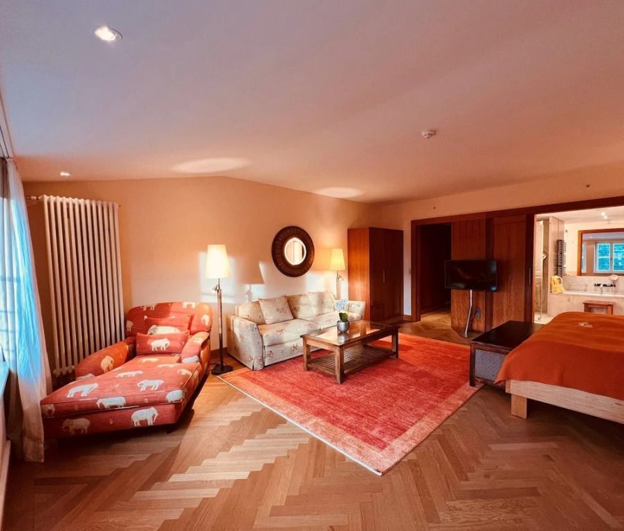 Elegantes Wohnzimmer mit Sofa und Sessel in der Deluxe Doppel Junior-Suite.