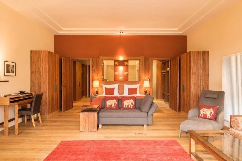 Geräumiges Schlafzimmer mit eleganter Einrichtung und Bett mit exotischen Kissen.
