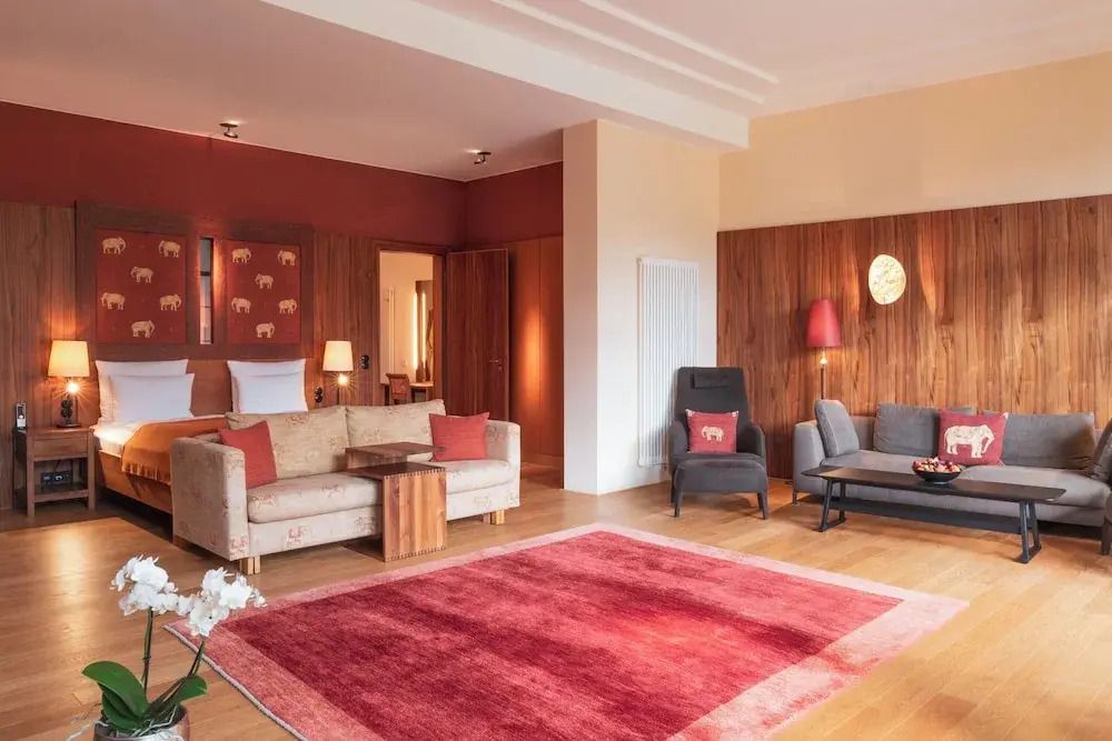 Großzügiges Zimmer mit rotem Teppich und stilvoller Dekoration. Warme Holzwände.
