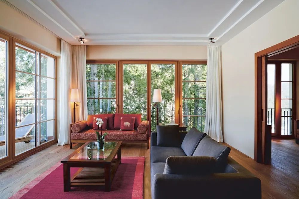 Lichtdurchflutetes Wohnzimmer mit großen Fenstern und Waldblick.