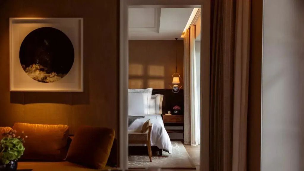 Elegantes Schlafzimmer mit Seeblick und luxuriösen Möbeln in warmen Farben