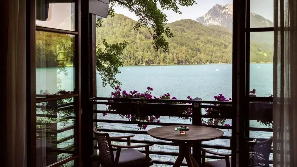 Balkonblick auf einen See mit Bergen im Hintergrund und Blumendekoration