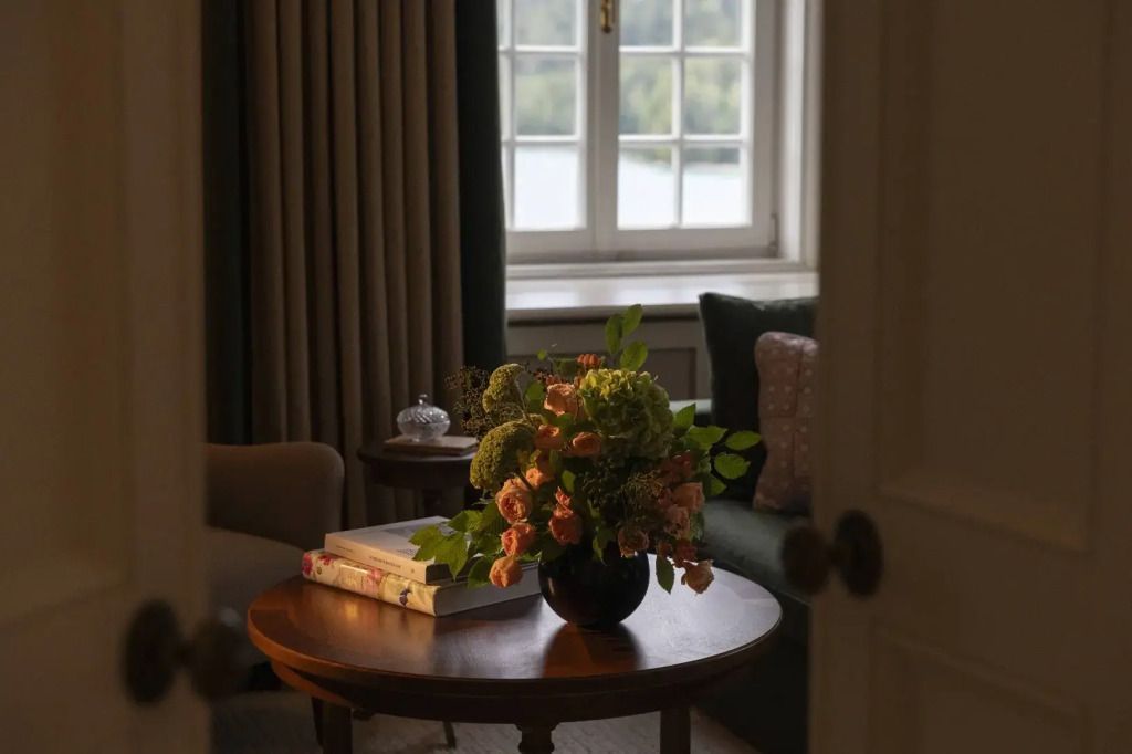 Blumenarrangement mit Seeblick durch Fenster im eleganten Zimmer