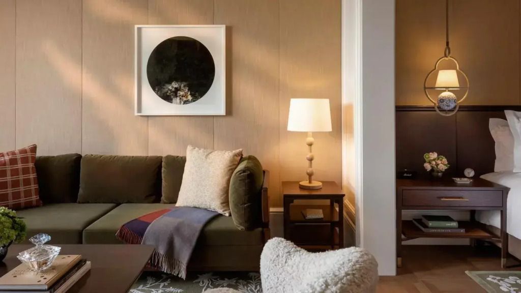 Gemütlicher Sitzbereich mit Kunst an der Wand und einer Stehlampe in einer Suite