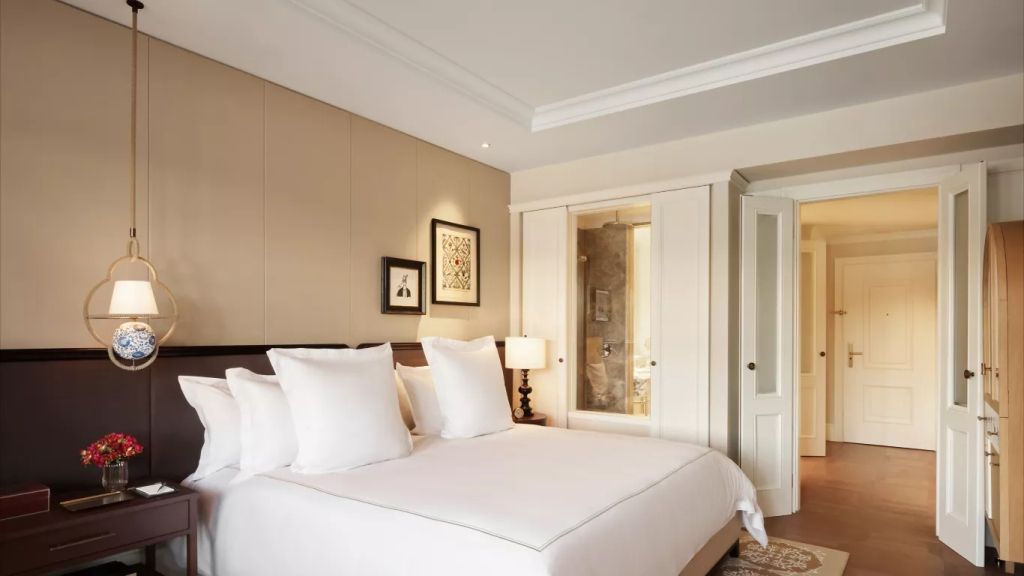 Doppelbett in der Heritage Doppel Suite mit luxuriöser Bettwäsche und stilvollen Kunstwerken