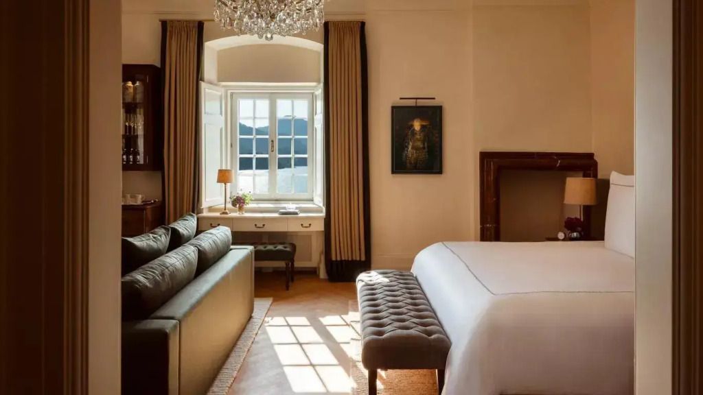 Elegantes Doppelzimmer mit Schlafzimmeransicht. Luxuriöser Kronleuchter und Fenster mit Ausblick.