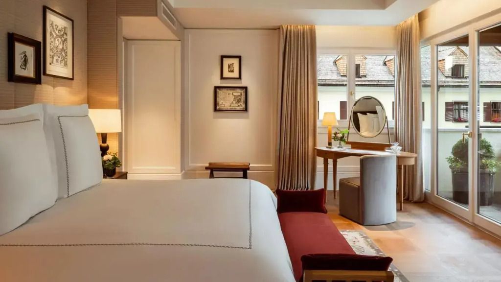 Elegantes Schlafzimmer mit großem Bett, Schreibtisch und dekorativen Elementen.