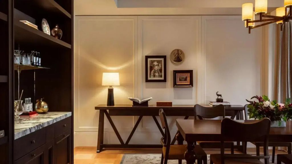 Schreibtischbereich mit Lampe und Kunstwerken an der Wand, elegantes Design.