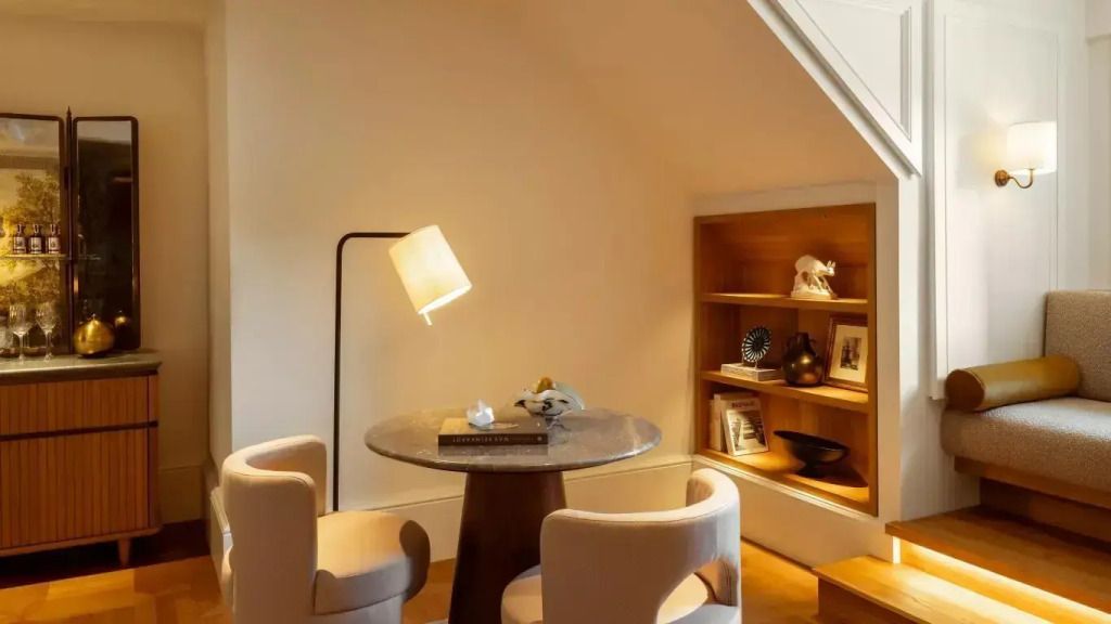 Edler Essbereich mit Tisch, zwei Stühlen und stilvollen Dekoelementen in einer Suite