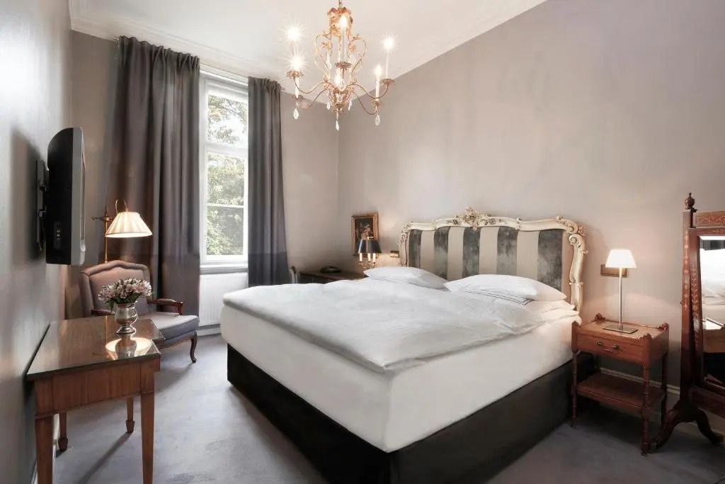 Deluxe Doppelzimmer mit elegantem Kronleuchter und großem Fenster im Schlosshotel Berlin
