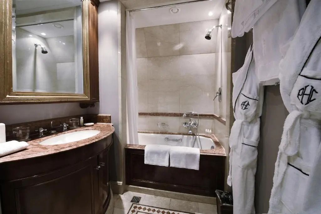 Elegantes Badezimmer mit Marmorwaschbecken und Badewanne im Schlosshotel Berlin