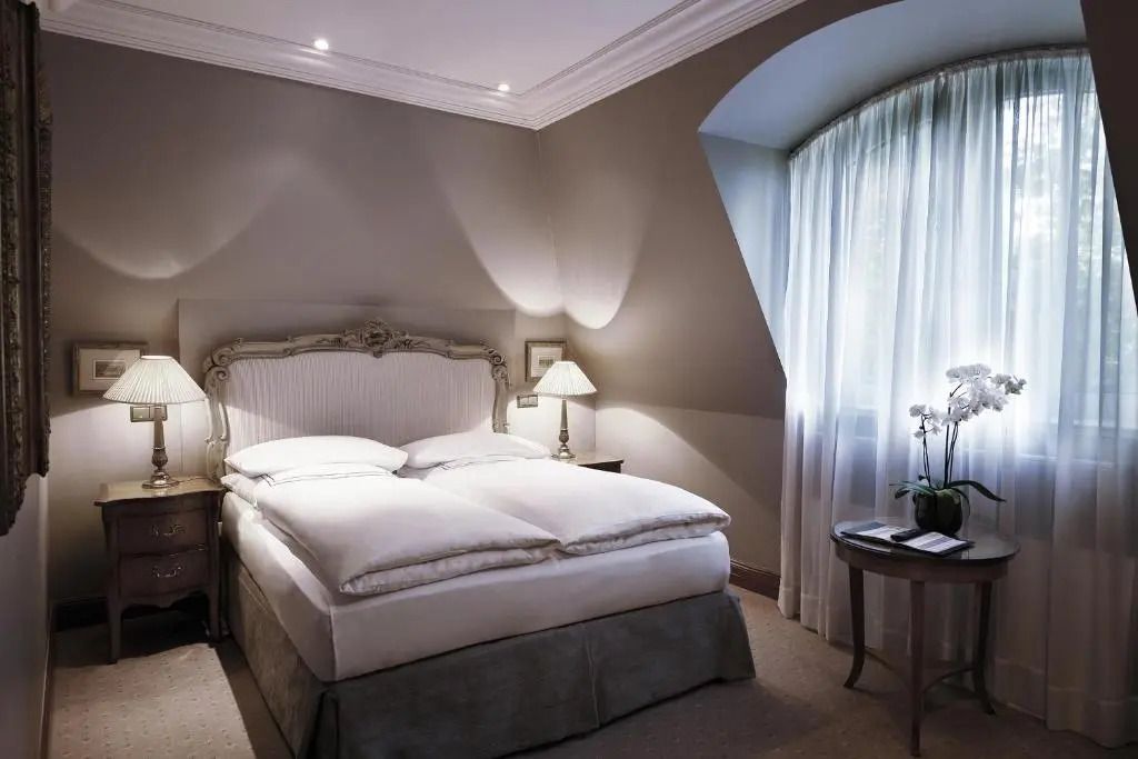 Geräumiges Deluxe Doppelzimmer mit kunstvollem Bettgestell und gemütlicher Sitzecke