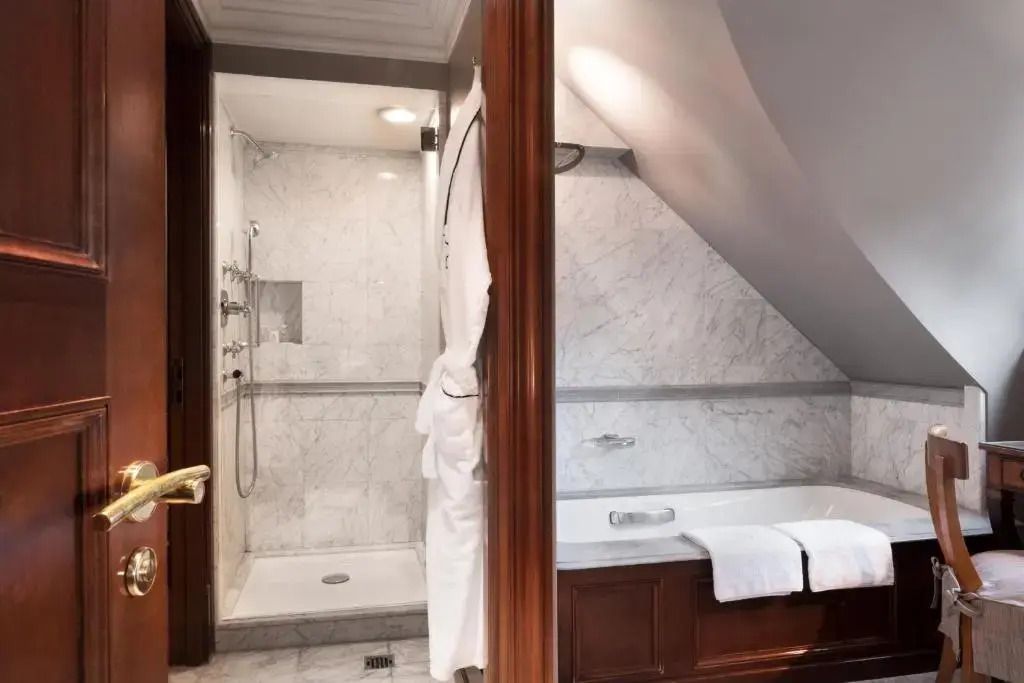 Luxuriöses Badezimmer mit Dusche und Badewanne aus Marmor.