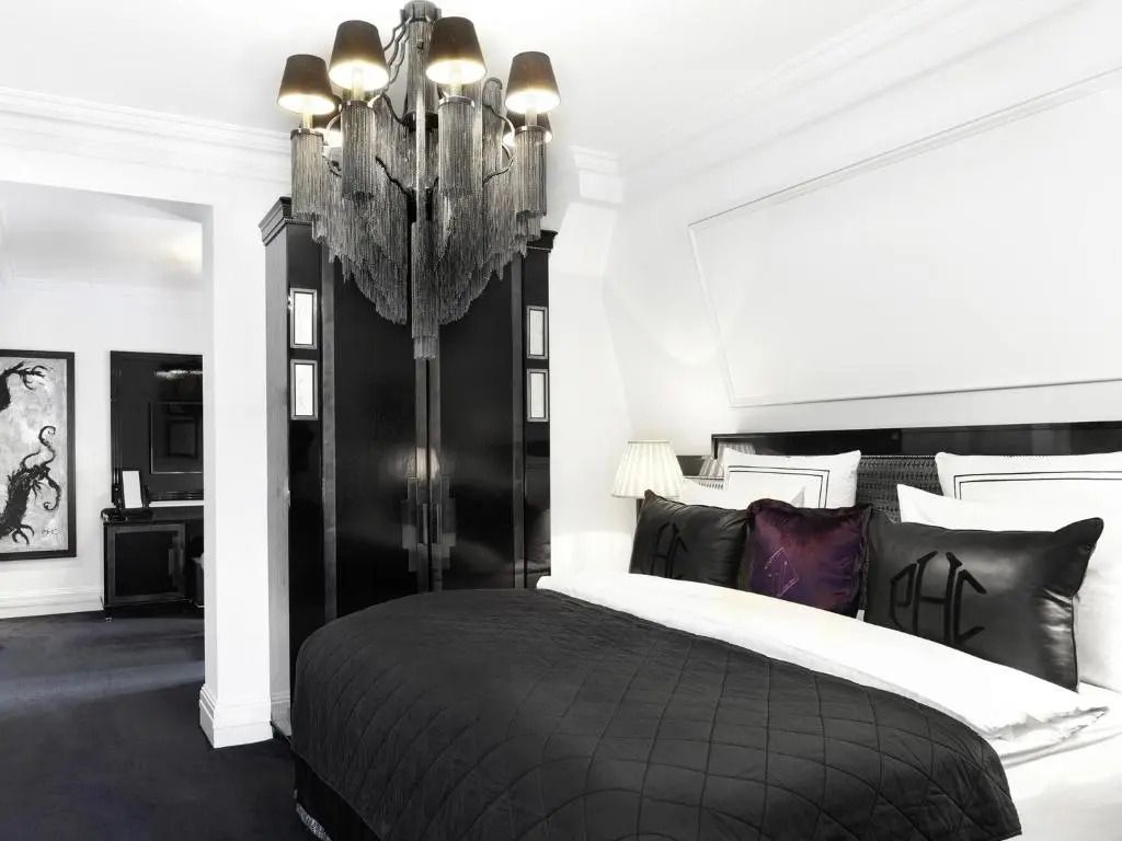 Elegantes Schlafzimmer mit imposantem schwarzen Kleiderschrank und stilvollem Beleuchtungselement