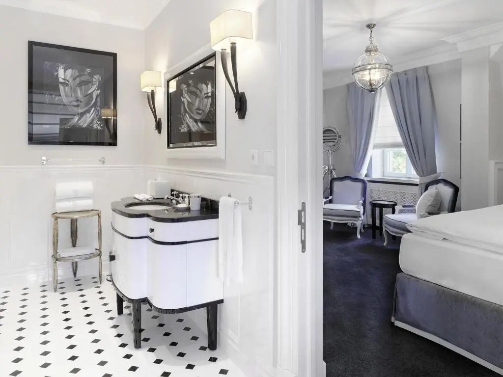 Schlankes Badezimmer mit schwarz-weißen Fliesen und eleganten Armaturen.