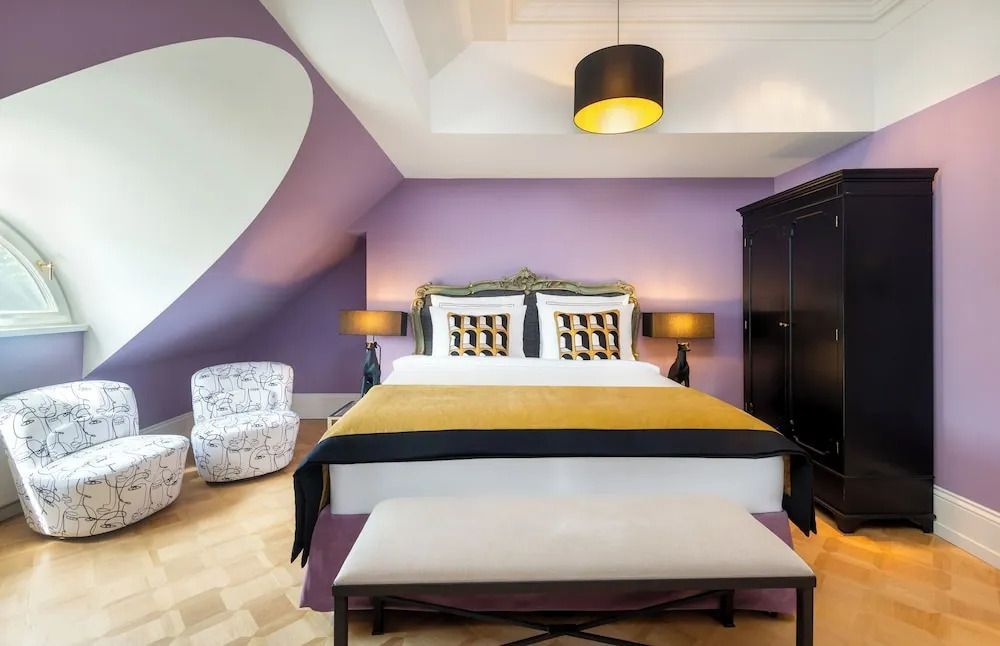 Elegantes Standardzimmer mit lila Akzentwand und stilvollen Möbeln