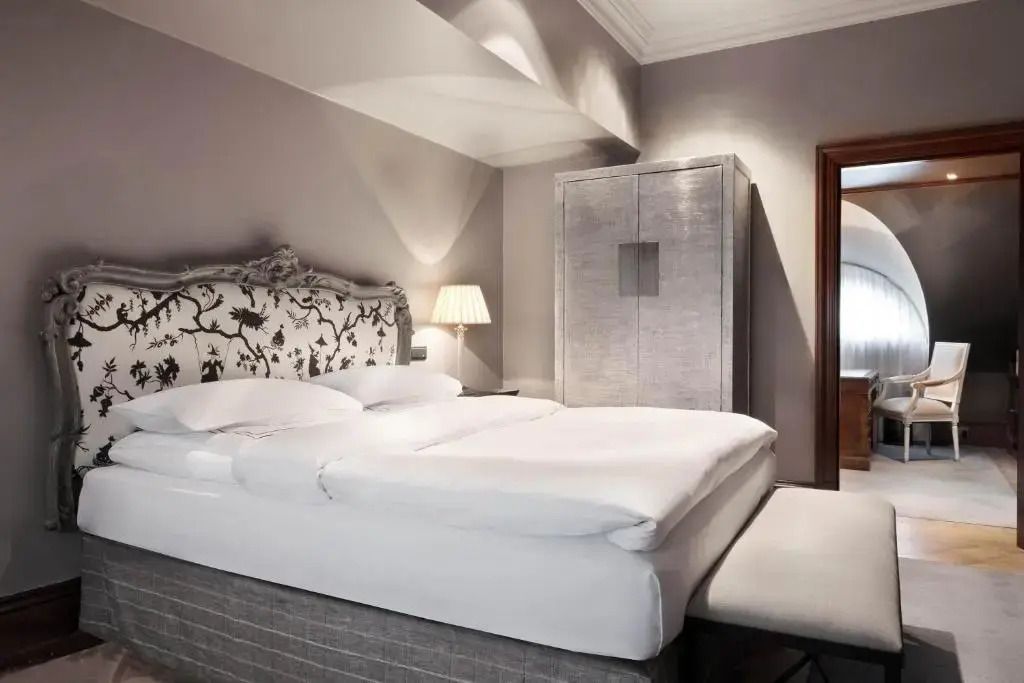 Suite im Schlosshotel Berlin mit luxuriösem Kingsize-Bett und stilvollen Möbeln