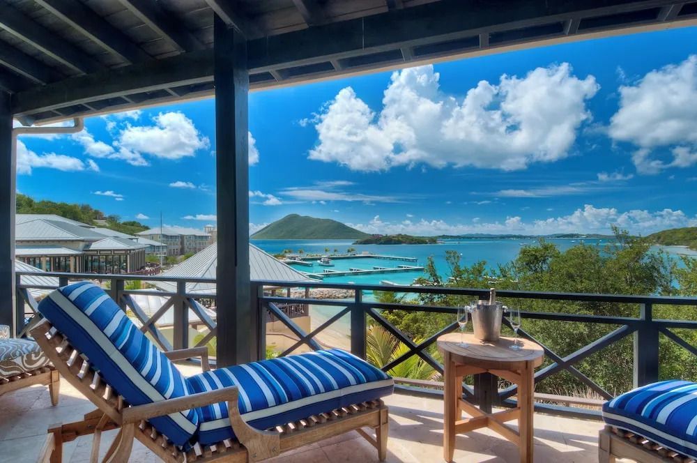 Große Terrasse mit Liegestuhl und Blick auf türkisblaues Meer und Inseln.