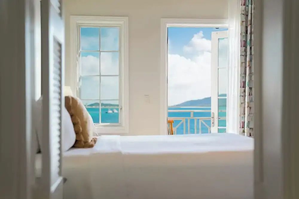 Zimmer mit Doppelbett und Balkon mit Blick auf das Meer und Himmel