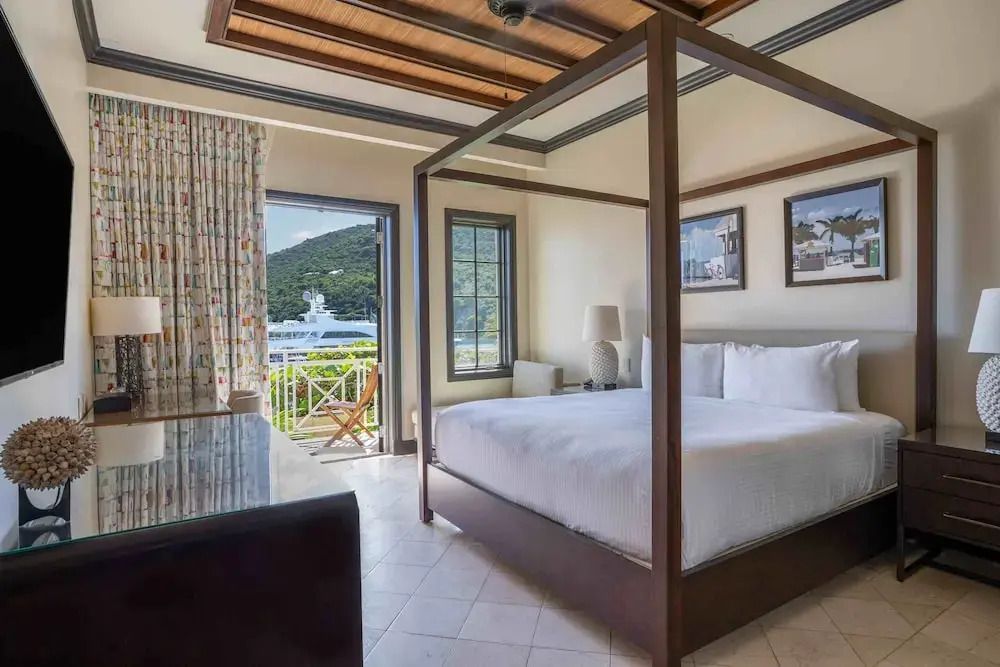 Schlafzimmer mit Himmelbett und Blick auf die Natur und das Meer.