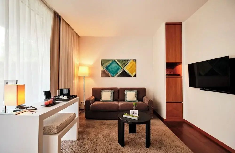 Komfortabel eingerichtetes Hotelzimmer mit Sofa und Kunstwerk an der Wand