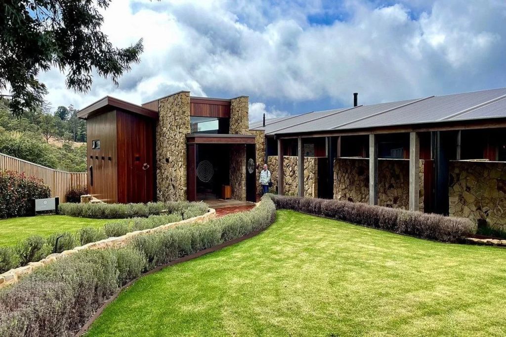Eingang einer modernen Villa mit Steinelementen und gepflegtem Garten