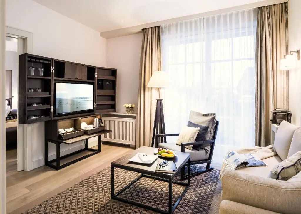 Elegantes Wohnzimmer im Deluxe Doppelzimmer mit gemütlichem Sofa und modernem TV