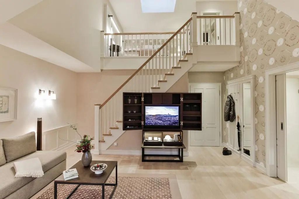 Luxuriöser Wohnbereich mit Treppe und Fernseher in der Junior-Suite