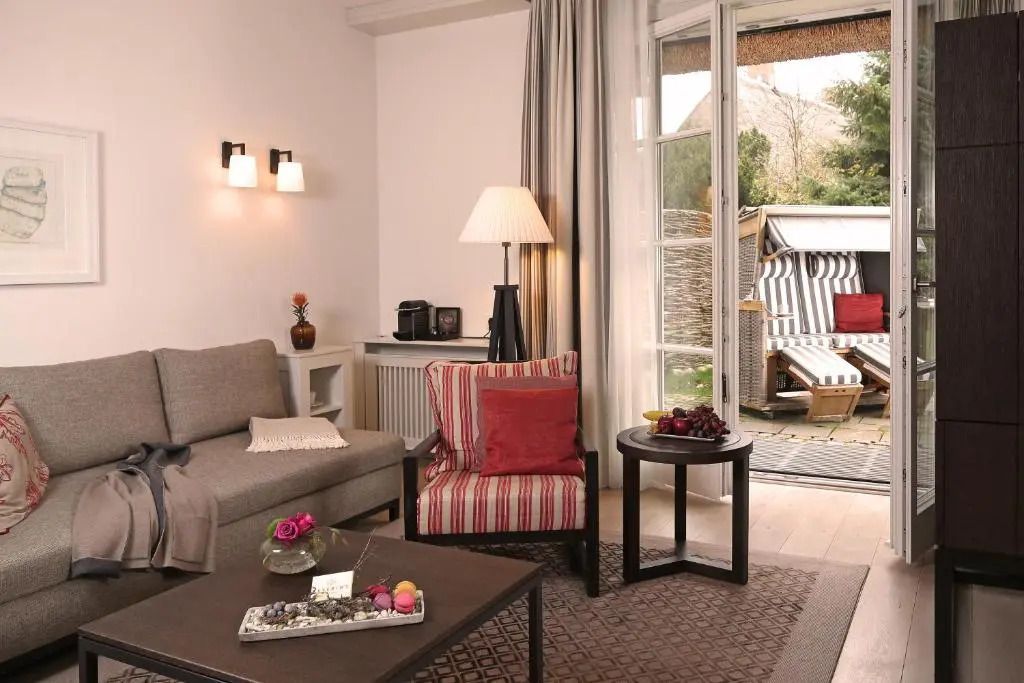 Wohnbereich einer Suite mit Zugang zur Terrasse und Strandkorb