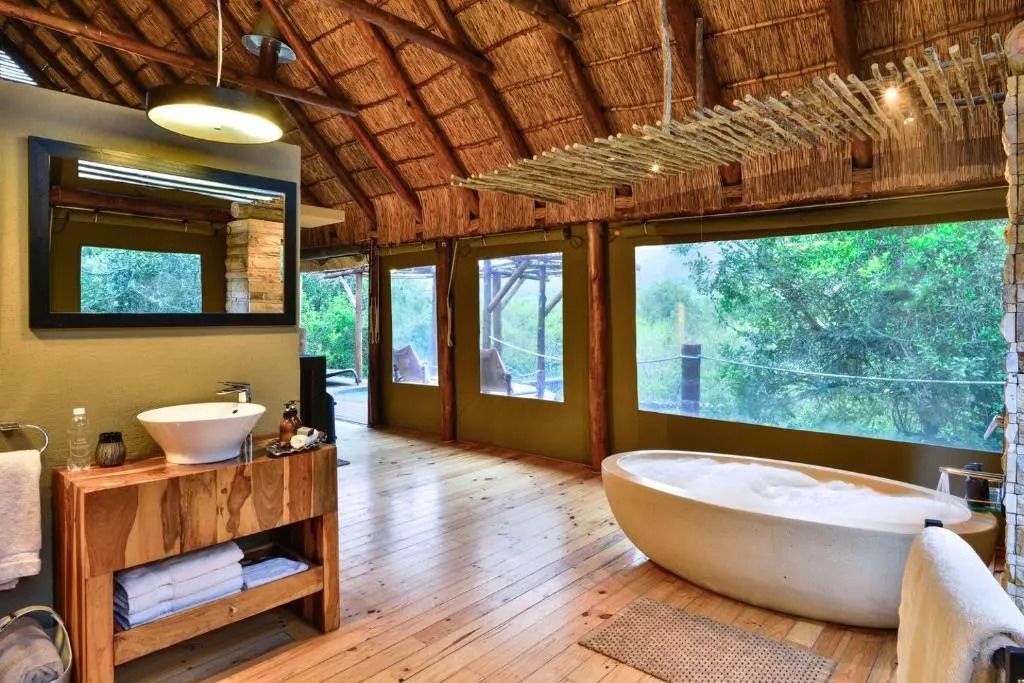 Luxuriöses Badezimmer mit freistehender Badewanne und großen Fenstern