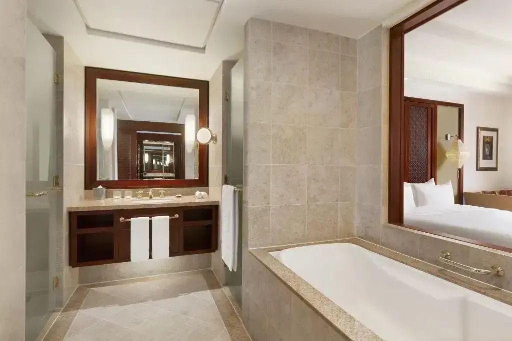 Modernes Badezimmer in der Deluxe Suite mit Badewanne und großen Spiegeln